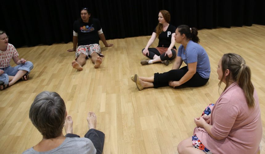 Students sitting in a circle participating in improv class